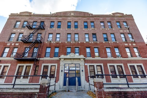 A red brick building with a blue door and windows.