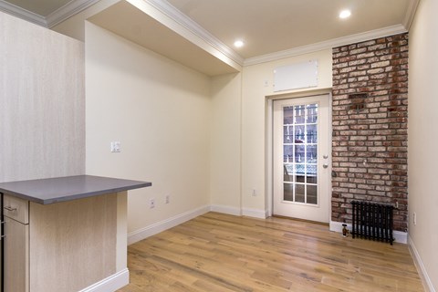 A room with a brick wall and a window.
