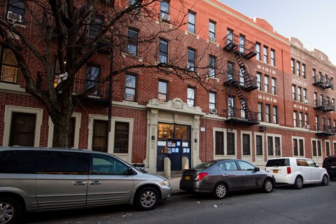 A silver minivan is parked on the side of a street.