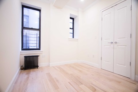 A room with a window and a radiator on the floor.