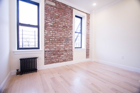 A room with a brick wall and a window.
