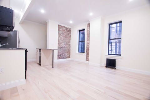 A room with wooden floors and a brick wall.