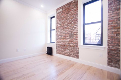 A room with a brick wall and a window.