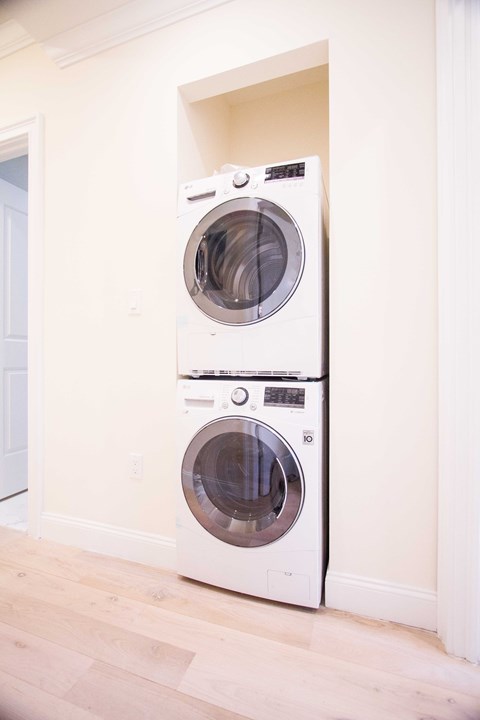Two white front loading washing machines in a laundry room.