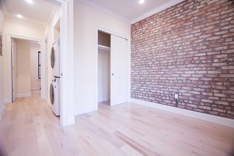 A room with a brick wall and wooden floors.