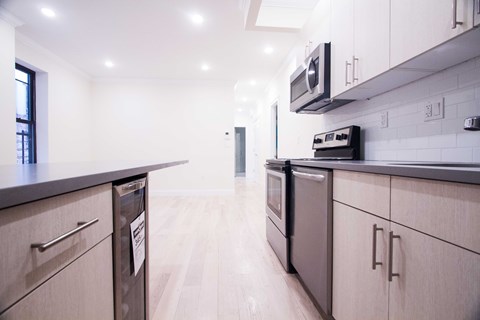 A modern kitchen with wooden cabinets and stainless steel appliances.