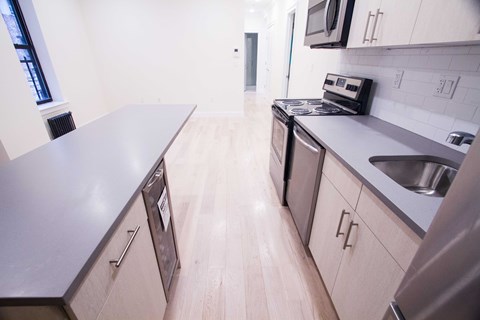 A kitchen with a stove, microwave, and oven.