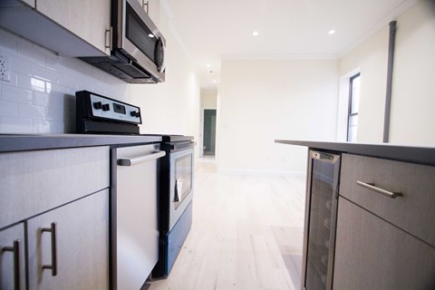 A modern kitchen with a white tile backsplash and dark cabinetry.