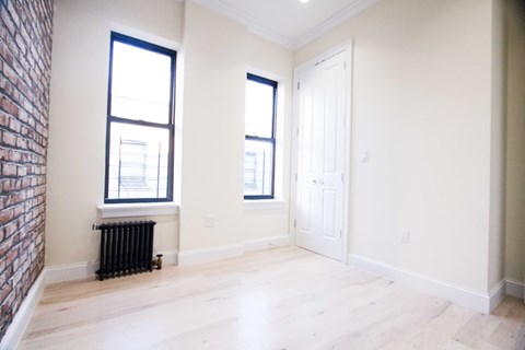 A room with a brick wall and a white door.