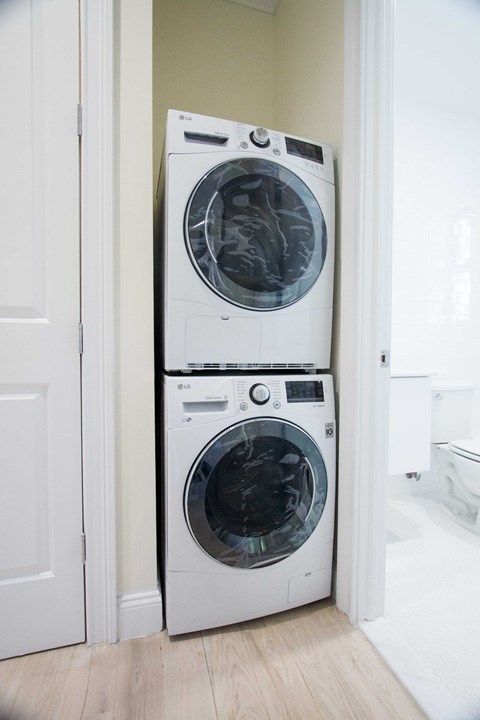 Two white front loading washing machines in a small room.