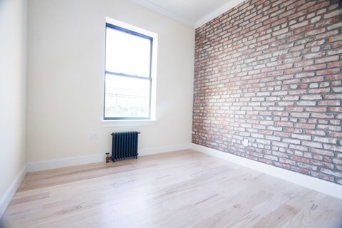 A room with a brick wall and a window.