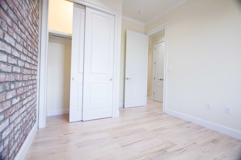 A room with a brick wall and white doors.