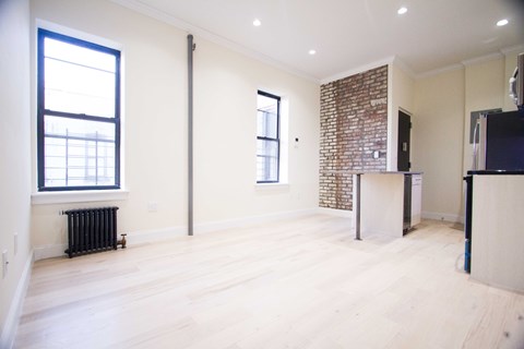 A room with a brick wall and wooden floors.
