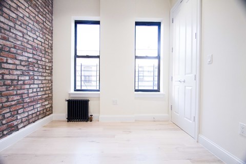 A room with a brick wall and a white door.