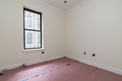 A room with a window and a wall socket.