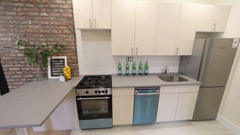 A kitchen with a brick wall and a stove top oven.