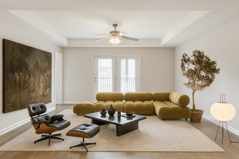 A living room with a yellow couch and a brown rug.