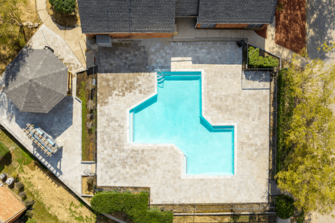 An aerial view of a house with a blue pool in the backyard.