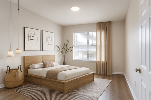 A bedroom with a large bed and two lamps on the wall.