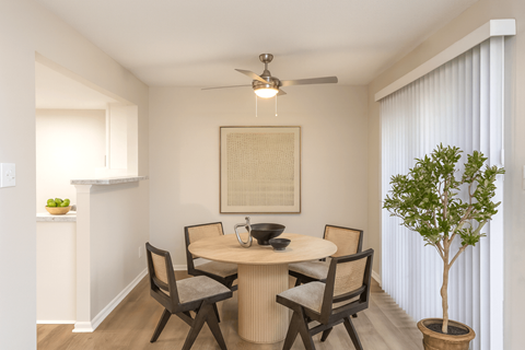 A dining room with a round table and chairs.