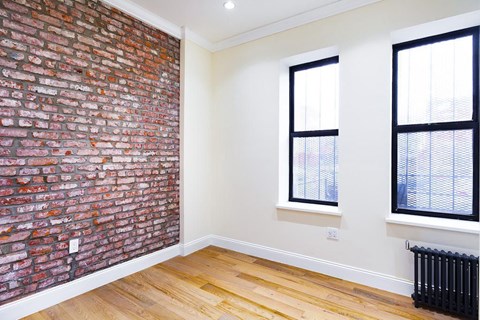 A room with a brick wall and a window.
