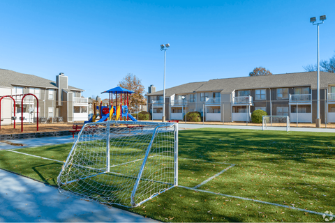 A soccer goal stands in the middle of a grassy field.