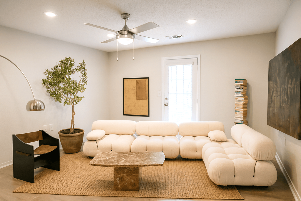 A living room with a white couch and a brown rug.