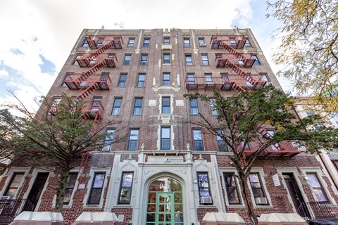 A tall building with a green door and windows on the side.