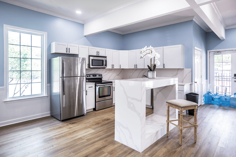 A kitchen with a white island and stainless steel appliances.