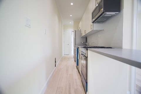 A long hallway with a kitchen on the right side.