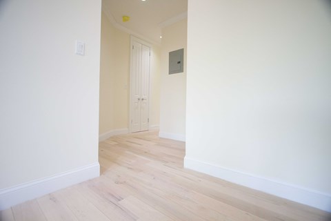 A room with a white door and a light switch on the wall.