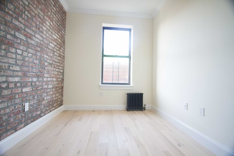 A room with a brick wall and a window.