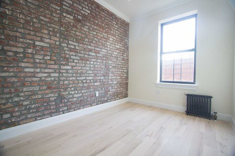 A room with a brick wall and a window.