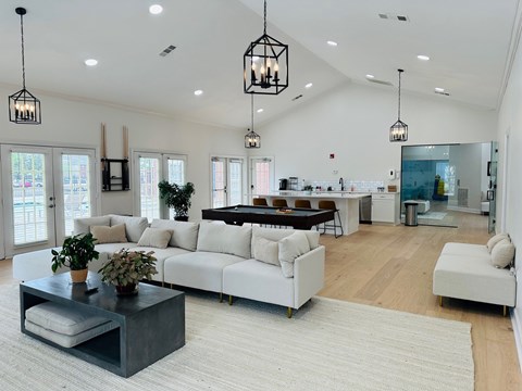 A modern living room with a white sofa set and a coffee table with a plant on it.