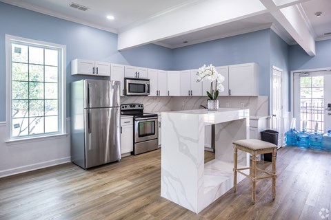 A kitchen with a white island and stainless steel appliances.