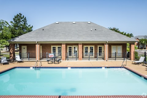 A house with a pool in front of it.