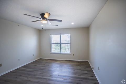 A room with a ceiling fan and a window.