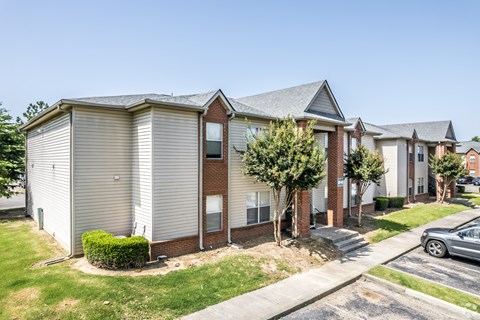 A row of houses with a car parked in front of them.