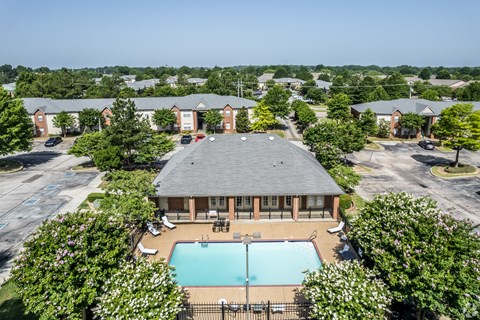 A swimming pool is surrounded by a fence and trees.