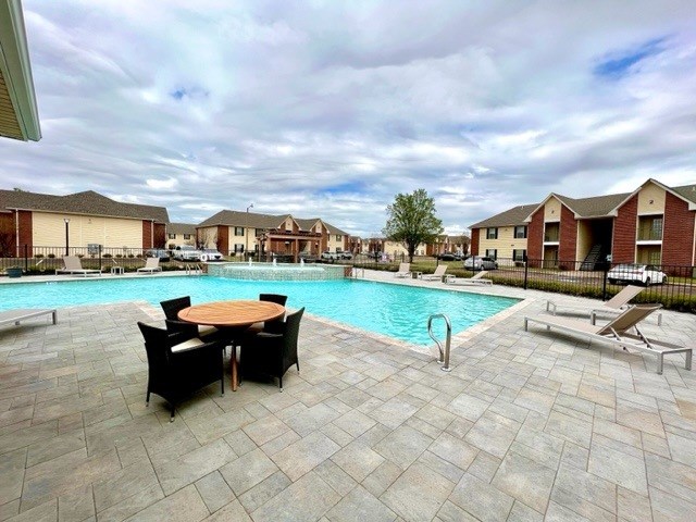 A pool area with a table and chairs.