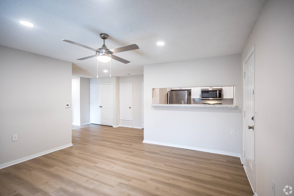 A room with a ceiling fan and wooden flooring.