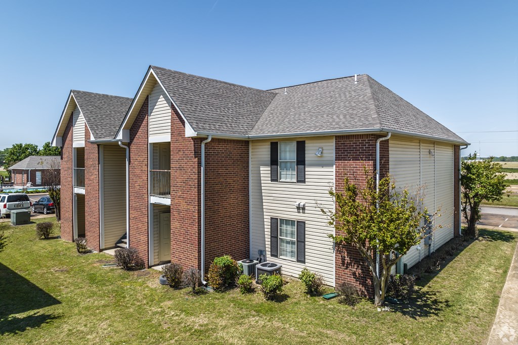 A brick house with a white trim and a grey roof.