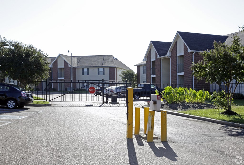 A street view of a residential area with a stop sign and a yellow pole.