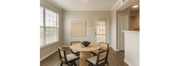 A dining room with a round table and chairs.