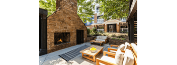 A patio with a fireplace and seating area.