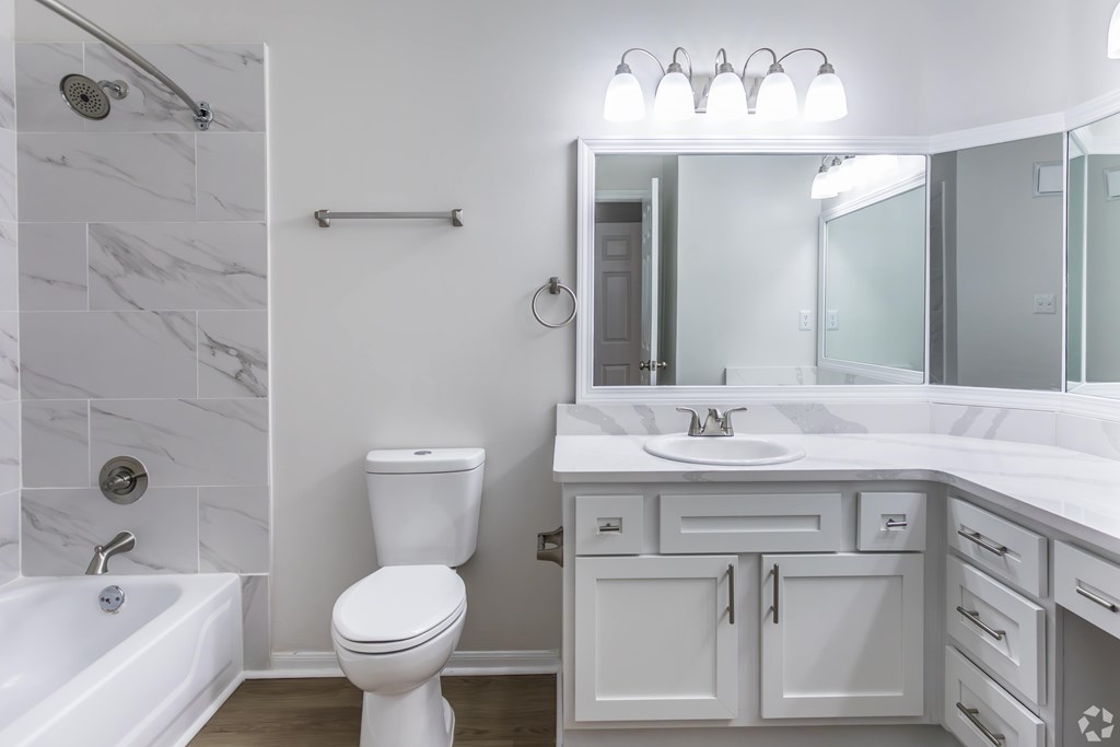 A white bathroom with a toilet, sink, and tub.