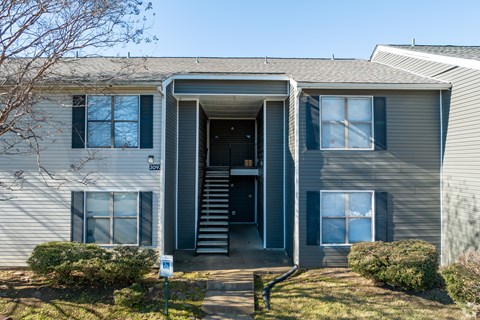 A house with a grey facade and a black door.
