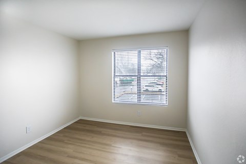 A room with a window and wooden flooring.