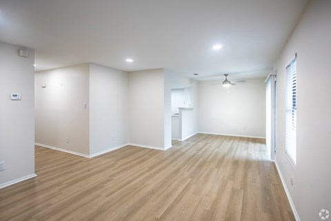 A room with wooden flooring and white walls.