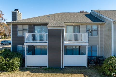 A two-story house with a balcony on the second floor.